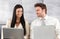 Elegant couple sitting on sofa using laptop