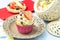 Elegant, creamy cupcake decorated with fruits, chocolate, and gold sprinkles on a romantic plate. Patisserie dessert with coffee i