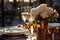 Elegant date table for two with white plates, vine glasses, cooper dishes and bucket with white roses on a bronze color surface
