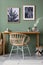Elegant details of modern interior design with wooden vanity table, painting and stylish personal accessories. Green wall. Mock up