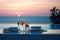 Elegant dining setup with wine glasses against a sunset sea view
