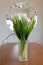 Elegant display of white flowers in a vase on a rustic wooden table top