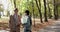 Elegant, elderly couple with bouquet of flowers talking with gestures in park