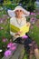 Elegant elderly lady reading in the garden