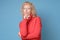 Elegant elderly lady in red sweater wearing glasses looking at the camera