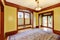 Elegant empty living room with yellow walls, carved wood doorway