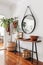 Elegant entryway with a sleek console table, round mirror, and modern accessories in a minimalist design