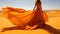 Elegant fashion model in a long dress gracefully posing in desert sands on a sunny day