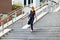 Elegant fashionable woman descending exterior steps in town