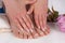 Elegant French Manicure and Pedicure: Beautiful Female Hands and Feet in Beauty Salon