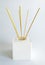 Elegant front view of white mikado air freshener with wooden sticks on white background. Close up of Aroma diffuser with bamboo