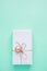 Elegant Gift Box Wrapped in White Paper Tied with Twine Pink Bauble Hanging. Christmas New Years Presents Shopping Sale.
