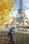 Elegant girl on embankment in Paris, France sitting on parapet