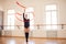 Elegant girl performing rhythmic gymnastics in studio