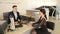 An elegant girl talking to a car salesman sitting at a table in the showroom.