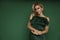 Elegant glamour blonde woman in evening feather green dress on green background in studio