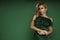 Elegant glamour blonde woman in evening feather green dress on green background in studio