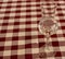 Elegant glass with alcohol on checkered red and white tablecloth. Glass of white wine. Drinks and beverages concept.