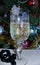 Elegant glass of champagne on the background of a Christmas tree. Black agate beads. Champagne bubbles in the glass.