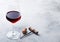 Elegant glass of red wine with cork and opener on stone kitchen table background.