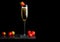 Elegant glass of yellow champagne with strawberry on top and fresh berries on black marble board on black background. Space for