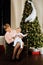 Elegant grandmother with a child in her arms on the background of a Christmas tree.