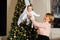 Elegant grandmother with a child in her arms on the background of a Christmas tree.