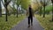 Elegant handsome man with long grey beard walking alone road in autumn park.