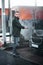 Elegant and handsome young man washing his car outdoors in a carwash under high pressured water