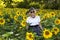 Elegant happy senior woman in sunflower field on summer day