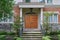 Elegant home entrance with wood grain double door and portico