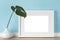 Elegant horizontal white picture frame with matte mockup, template with monstera leaf in vase in front of pastel blue wall