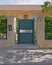 Elegant house external green metallic door and brown stone covered columns