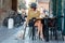 Elegant Italian woman with hat and glasses keeps her cat on a leash