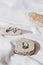 Elegant jewellery set of golden ring andearrings with blue topaz on white background with stones and wood. Minimal style