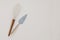 Elegant kitchen utensils, kitchenware. White silicon whisk and cake spoon with wooden handle isolated on beige table
