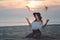 Elegant lady in floppy hat throwing sand sitting