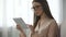 Elegant lady in glasses analysing email letters, checking inbox folder on tablet