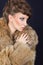 Elegant lady holding red wine glass wearing brown fur coat