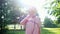 Elegant lady in long purple dress and hijab walks along park