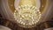 Elegant large luxury chandelier on the ceiling of restaurant or theatre. crystal lamp hanging