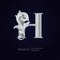 Elegant letter H with floral baroque ornament. Antique capital letter is surrounded with white decorations isolated on black