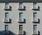 Elegant light grey facade with large windows and small white balconies with columns, in classical style