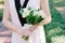 Elegant lily of the valley wedding bouquet in hands of the bride