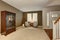 Elegant living room in brown tones with two classic armchairs and vanity cabinet.