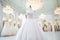 Elegant and luxurious white bridal dresses hanging on hangers in a beautiful boutique salon