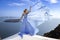 Elegant luxury evening fashion. Glamour, stylish elegant woman in long gown dress is posing outdoor in luxury resort in Santorini