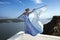 Elegant luxury evening fashion. Glamour, stylish elegant woman in long gown dress is posing outdoor in luxury resort in Santorini