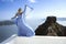 Elegant luxury evening fashion. Glamour, stylish elegant woman in long gown dress is posing outdoor in luxury resort in Santorini