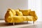 Elegant luxury upholstered yellow loveseat sofa against of window dressed with white curtain. Minimalist interior design of modern